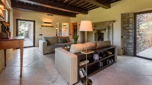 Un salon avec un canapé, une table basse, une lampe et une cheminée.