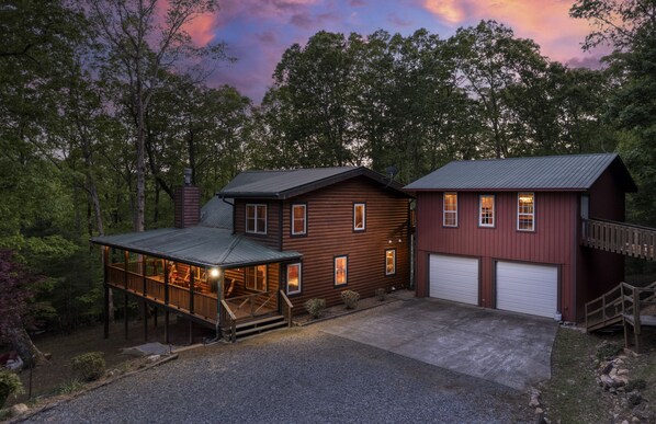 Een chalet met een overdekte veranda, een garage en een ruim terras.