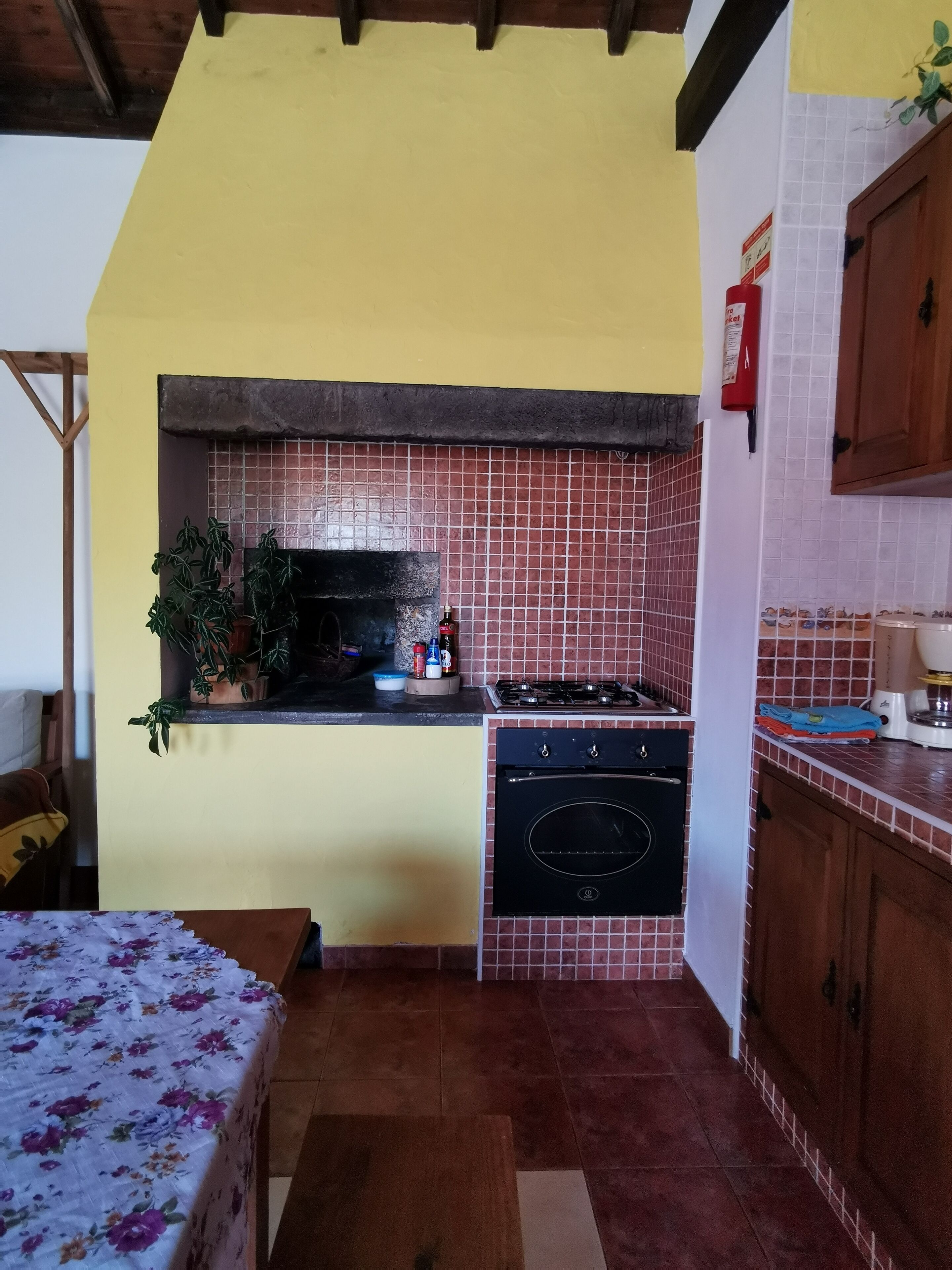 A compact kitchen with a tiled backsplash, a stove, and a sink.