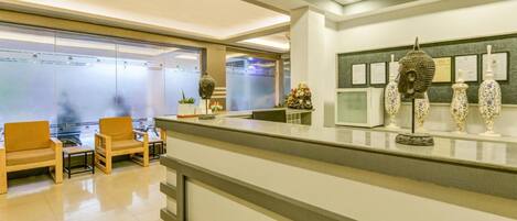 A reception area with a counter, seating, and decorative items.