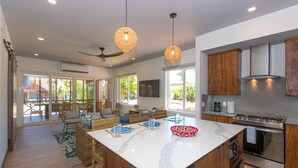 Una cocina moderna con una isla grande, armarios de madera y un ventilador de techo.