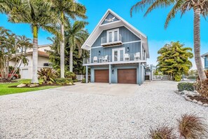 Ein zweigeschossiges Haus mit Balkon, Garage und Auffahrt.