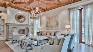 A spacious living room with a fireplace, a chandelier, and a large sofa set. - Lady Martinique | Exquisite 5 Bedroom with Private Pool, Outdoor Fireplace (Rosemary Beach)
