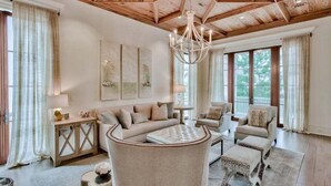 A spacious living room with a high wooden ceiling, a large chandelier, and a comfortable seating area with a sofa and armchairs. - Lady Martinique | Exquisite 5 Bedroom with Private Pool, Outdoor Fireplace (Rosemary Beach)