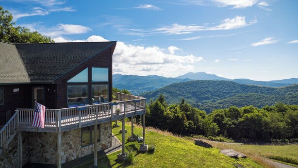 Un bâtiment en pierre doté d’un balcon, arborant un drapeau américain et offrant une vue sur les montagnes.