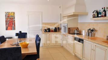 Een koelkast, een oven, een vaatwasser, kookgerei, borden en bestek