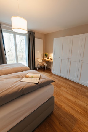 Une chambre avec un grand lit, un bureau et une armoire.