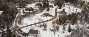 An aerial view of a residential area with houses, a winding road, and a parking lot. - Beach House Chalet - shared access to Rangeley Lake (Rangeley)