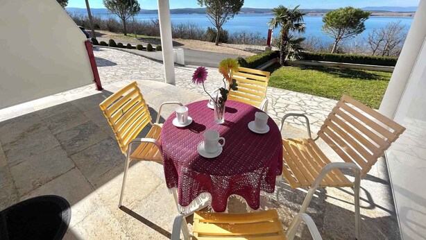 Une table dressée à l’extérieur, avec vue sur la mer.