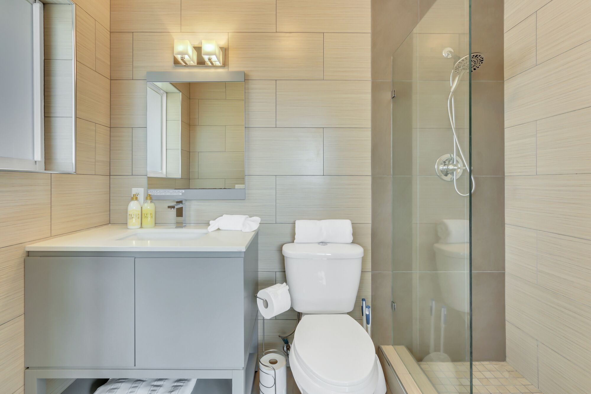 A modern bathroom with a toilet, sink, and shower.
