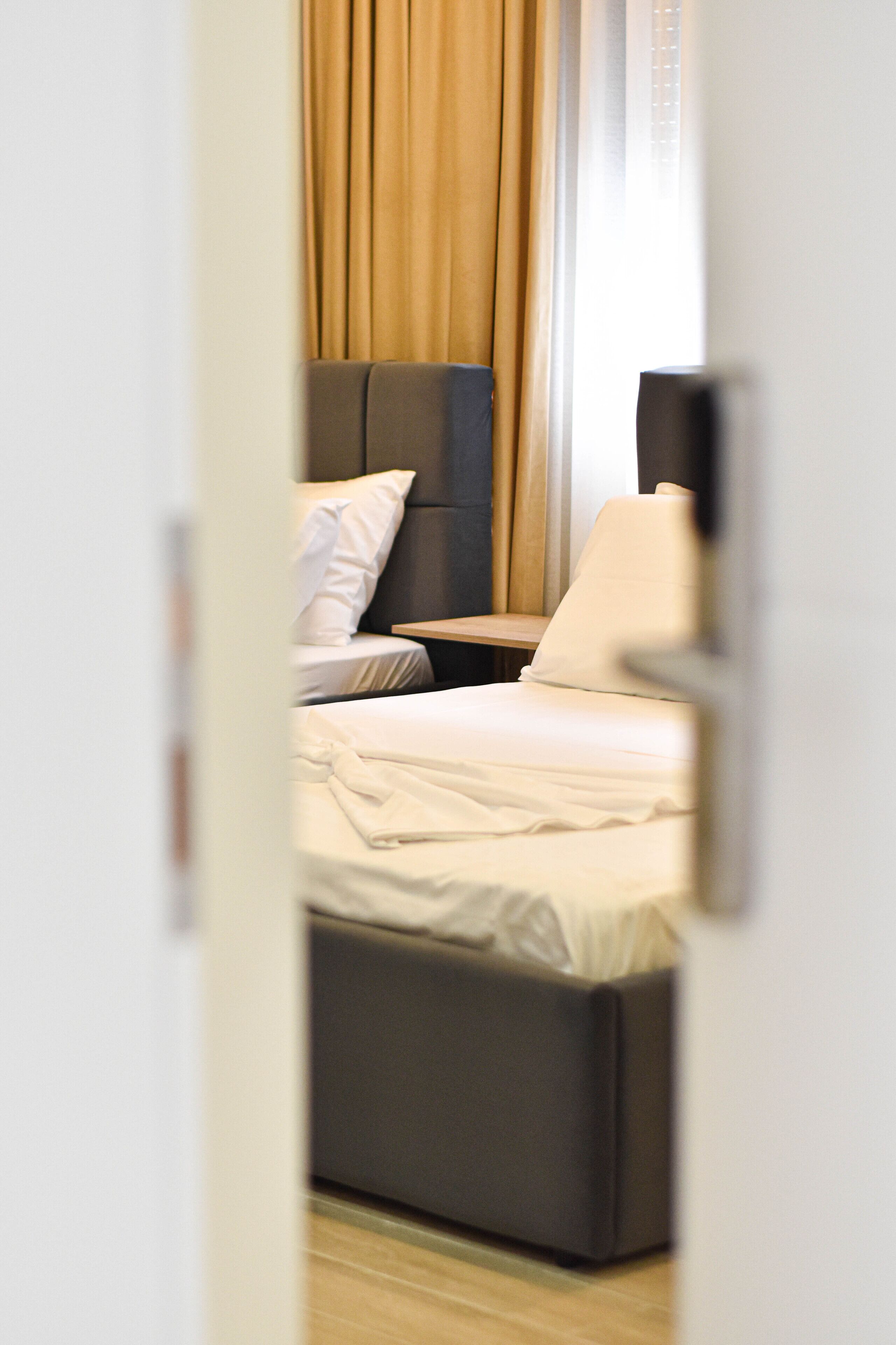 A hotel room with a bed, a bedside table, and a nightstand.