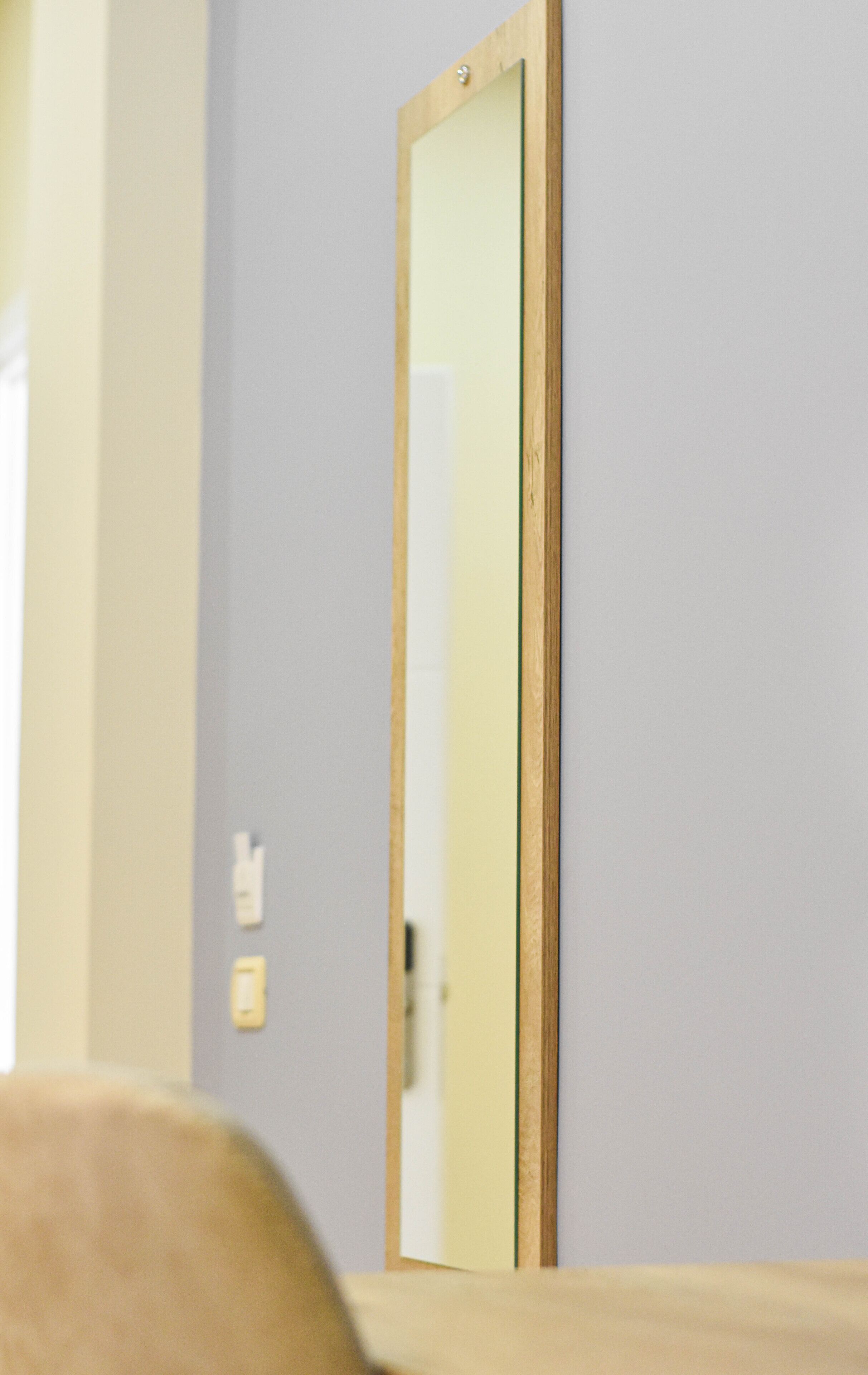 Une pièce avec une porte et un miroir au mur.
