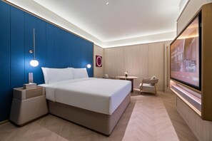 A hotel room with a large bed, bedside tables, a desk, a chair, a TV, and a wall-mounted artwork. - Crystal Orange Hotel Haimen Wenfeng Great World (Nantong)