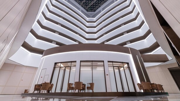 A modern atrium with a central staircase, glass doors, and seating area. - Crystal Orange Hotel Haimen Wenfeng Great World (Nantong)