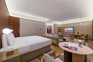A modern hotel room with a bed, a seating area with a coffee table, a TV, and a wardrobe. - Crystal Orange Hotel Haimen Wenfeng Great World (Nantong)
