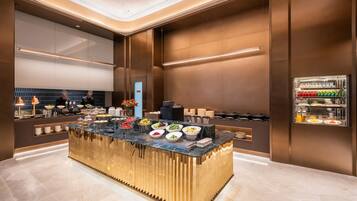 A modern breakfast bar with a variety of food options, a coffee station, and a beverage refrigerator.