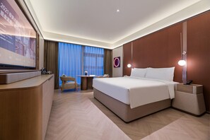 A modern hotel room with a large bed, a desk, a chair, and a television. - Crystal Orange Hotel Haimen Wenfeng Great World (Nantong)
