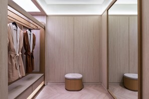 A walk-in closet with wooden paneling, a bench, and hanging robes. - Crystal Orange Hotel Haimen Wenfeng Great World (Nantong)
