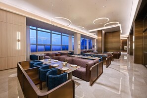 A modern dining area with high ceilings, large windows, and contemporary lighting fixtures. - Crystal Orange Hotel Haimen Wenfeng Great World (Nantong)