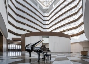 A grand atrium with a grand piano, high ceilings, and a checkered floor. - Crystal Orange Hotel Haimen Wenfeng Great World (Nantong)