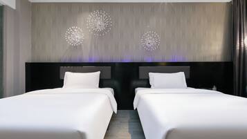 A hotel room with two beds, a patterned wallpaper, and a chandelier.