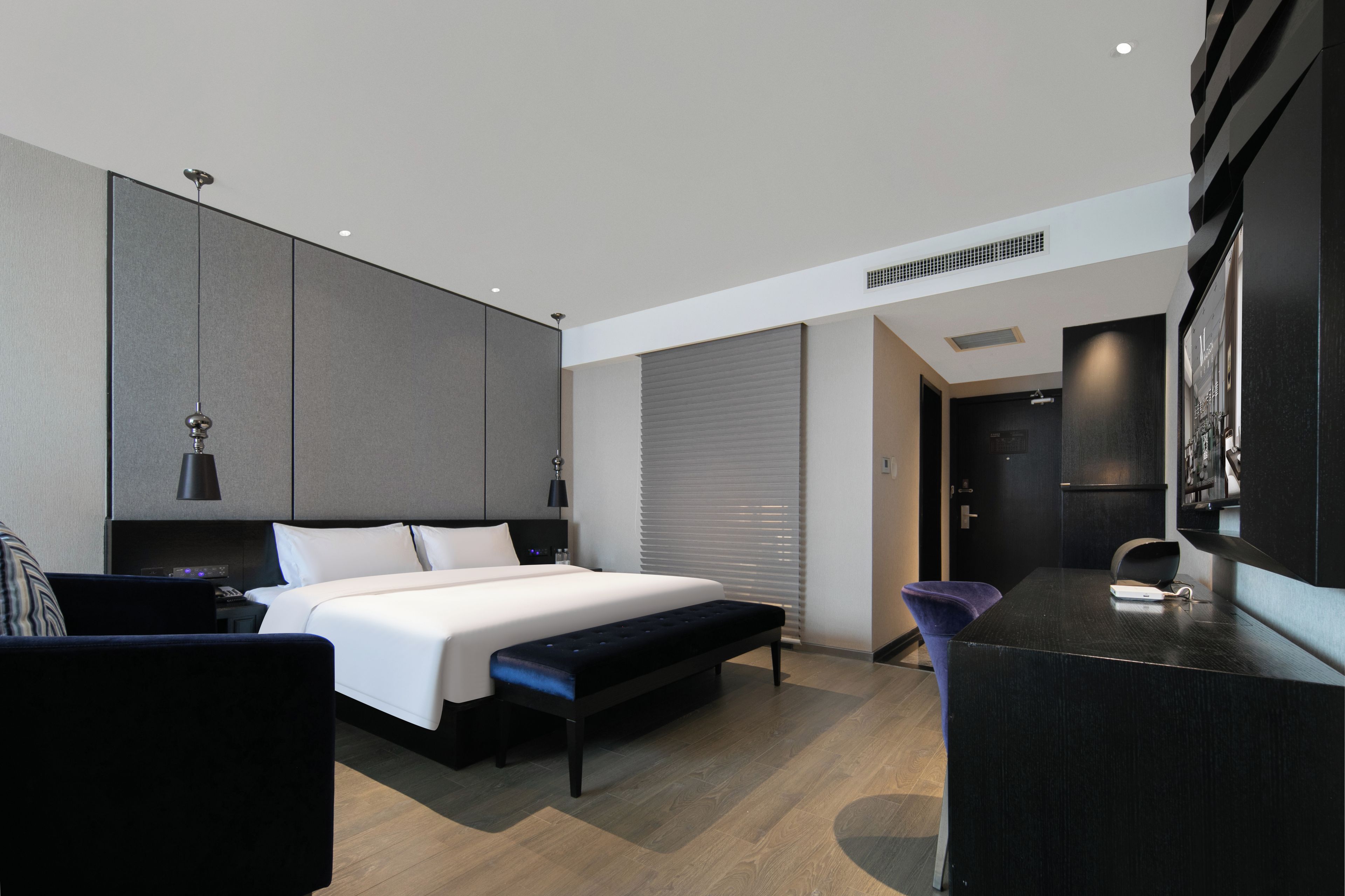 Habitació d'hotel moderna amb un llit gran, una taula de treball i una zona de seients.