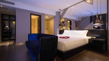 Habitació d'hotel moderna amb un llit gran, un escriptori, una cadira i un mirall.