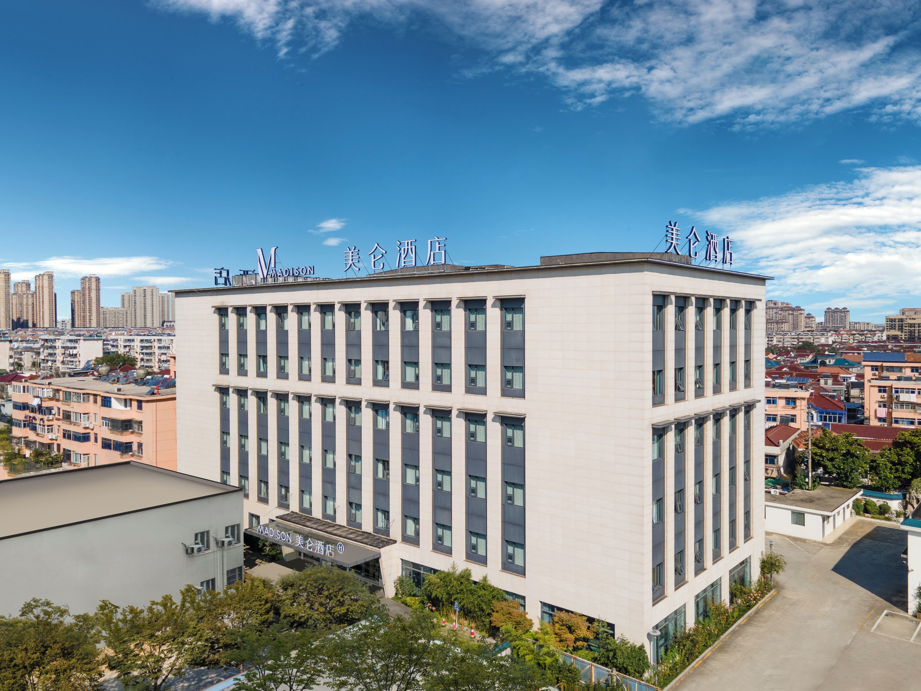 Un edifici d'hotel modern amb façana plana, nombroses finestres i indicadors que mostren que és l'Hotel Madison.