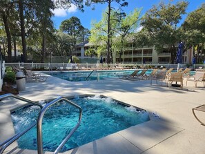 Un área de piscina con sillones reclinables y un jacuzzi.