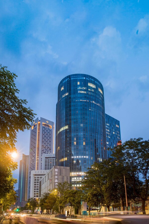 A modern high-rise building with a curved facade, surrounded by other tall buildings and trees. - Crystal Orange Hotel Nanjing Xinjiekou Center (Nanjing)