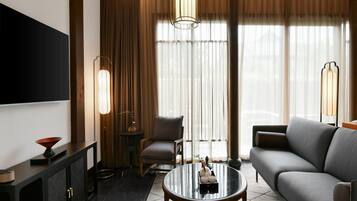 A modern living room with a sofa, a coffee table, a TV, and a lamp.