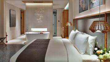 A modern hotel room with a large bed, a bathtub, and a wooden headboard.