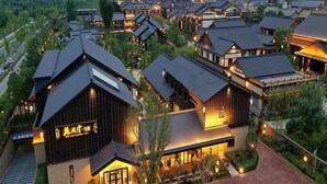 A traditional-style hotel with multiple buildings, a well-maintained garden, and a clear pathway leading to the entrance. - Blossom Hill Hotel Xian Shijingli (Xi'an)