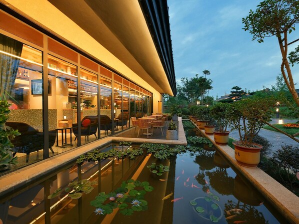 Un hôtel moderne doté d’un bar, d’une terrasse et d’un bassin orné de carpes koï.