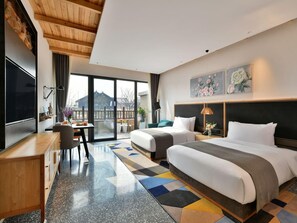 Una habitación de hotel moderna con una cama grande, un escritorio y un balcón con vistas.