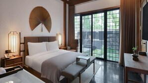 A modern hotel room with a large bed, bedside lamps, a bench, a desk, and a view of the outdoors through large sliding doors. - Blossom Hill Hotel Xian Shijingli (Xi'an)