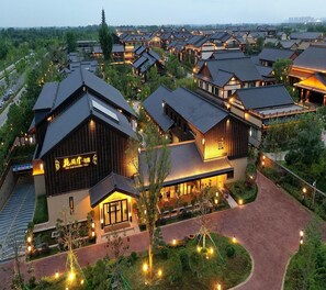 Un hotel de estilo tradicional con varias construcciones, un jardín cuidado y un camino despejado hacia la entrada.