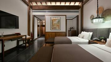 A hotel room with two beds, a wooden desk, a flat-screen TV, and a painting on the wall.