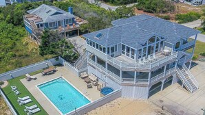A large two-story building with a pool and outdoor seating area. - C'EST FINI - Enjoy superb ocean views & great beach access from this 4,000 plus sqft. stunning home! (Southern Shores)