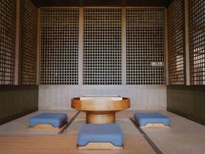 A traditional Japanese-style room with tatami mats, a central wooden table, and low blue cushions. - Blossom Hill Hotel Nanjing Lishui (Nanjing)
