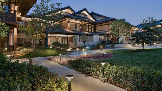 Un edificio de estilo japonés tradicional con fachada de piedra, vigas de madera y techo inclinado.