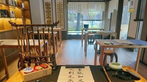 A traditional Japanese room with tatami flooring, a low table with a tea set, and a wooden chair. - Blossom Hill Hotel Nanjing Lishui (Nanjing)