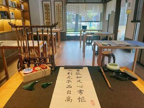 A traditional Japanese room with tatami flooring, a low table with a tea set, and a wooden chair. - Blossom Hill Hotel Nanjing Lishui (Nanjing)