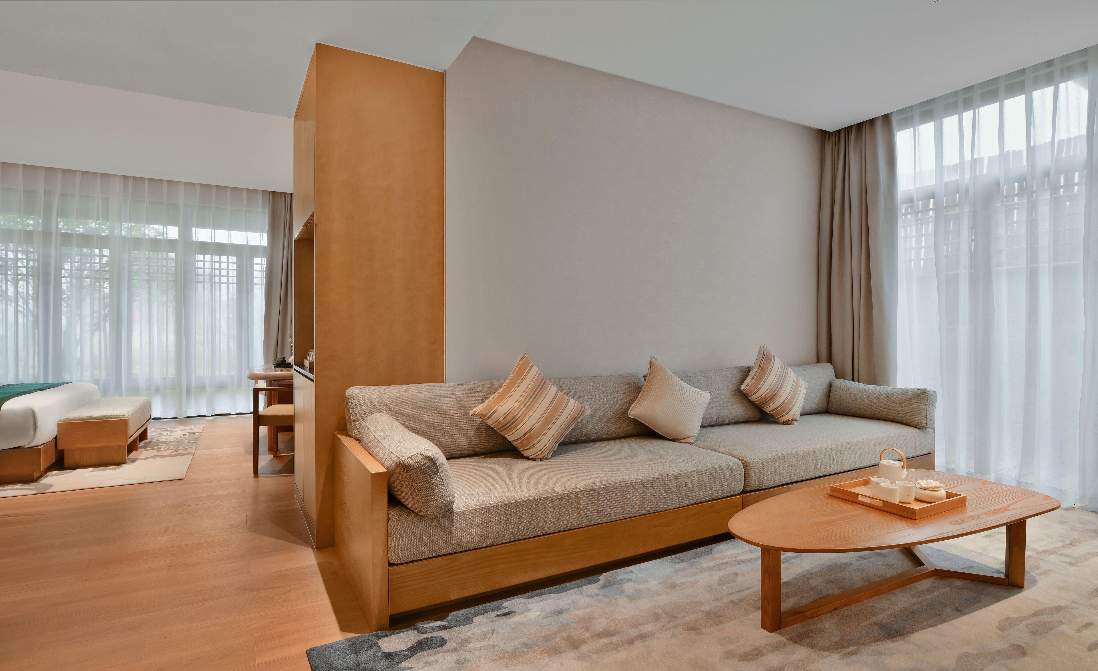 A modern living room with a sofa, a coffee table, and a desk.