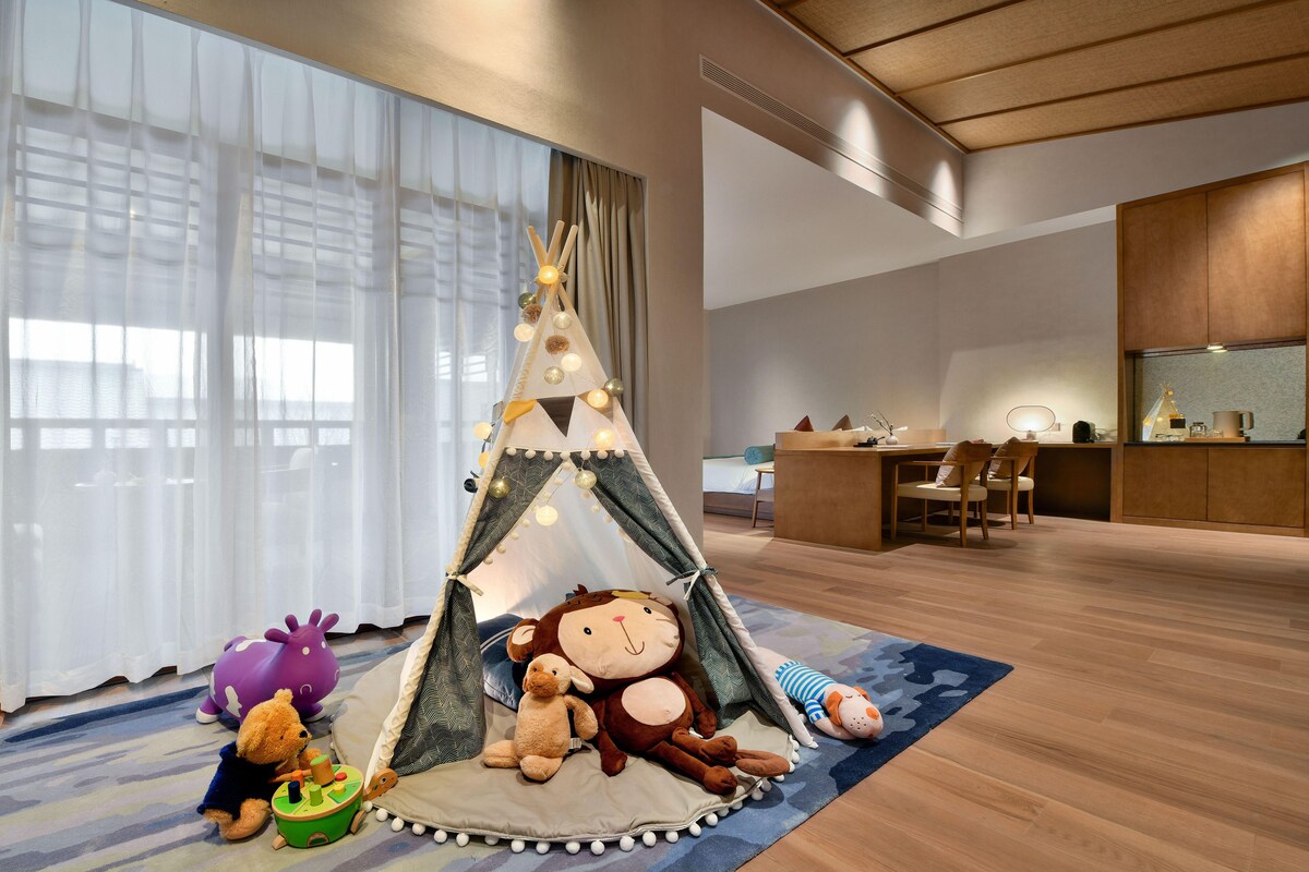 A cozy room with a play tent, plush toys, and a small table.