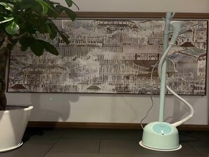 A room with a large wall mural, a standing fan, and a potted plant. - Blossom Hill Hotel Nanjing Lishui (Nanjing)