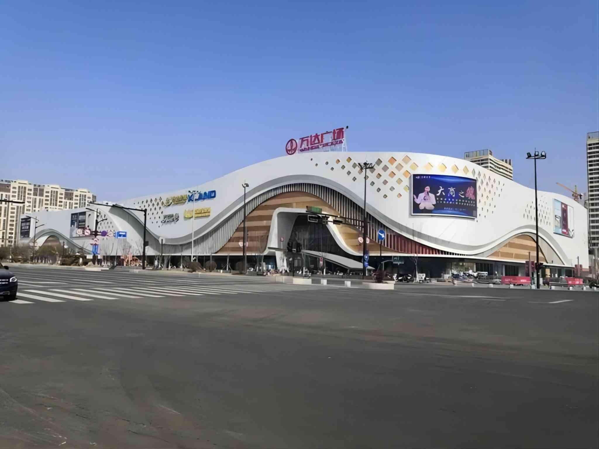 A modern building with a curved facade, multiple entrances, and a prominent sign.