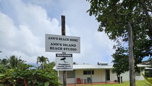 A sign for 'Ann's Beach Home' and 'Ann's Island Beach Studio' with a warning about 24-hour surveillance.