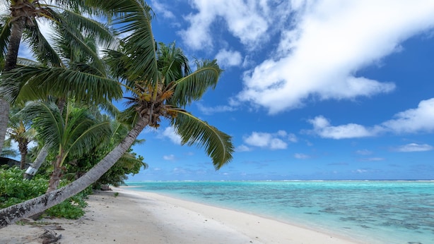A beach with white sand and clear turquoise water.