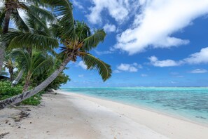 A beach with white sand and clear turquoise water.